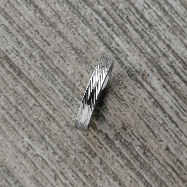 Anillo de acero inoxidable delgado en color plateado acabado brillante diseño diamantado. Ancho 4 mm.