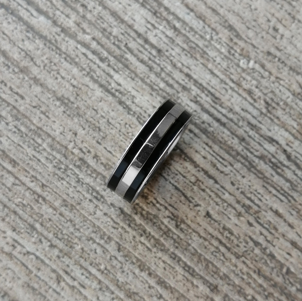 Anillo de acero inoxidable en color plateado acabado brillante y líneas negras. Ancho 7 mm.